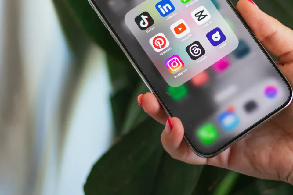 Mão segurando celular com WhatsApp e outros apps de mensagem entre os aplicativos do dia a dia