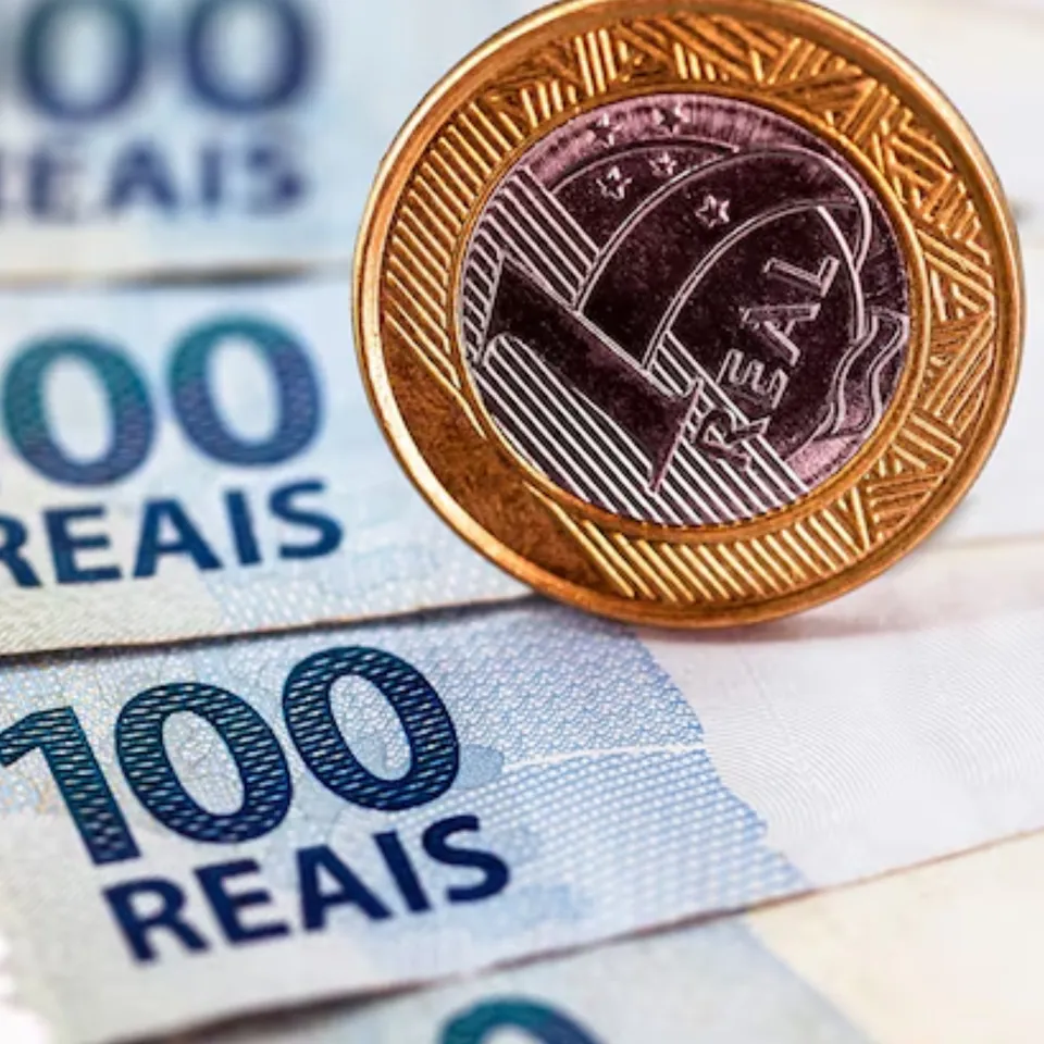 Notas de cem reais e moedas contadas sobre a mesa do fechamento do caixa